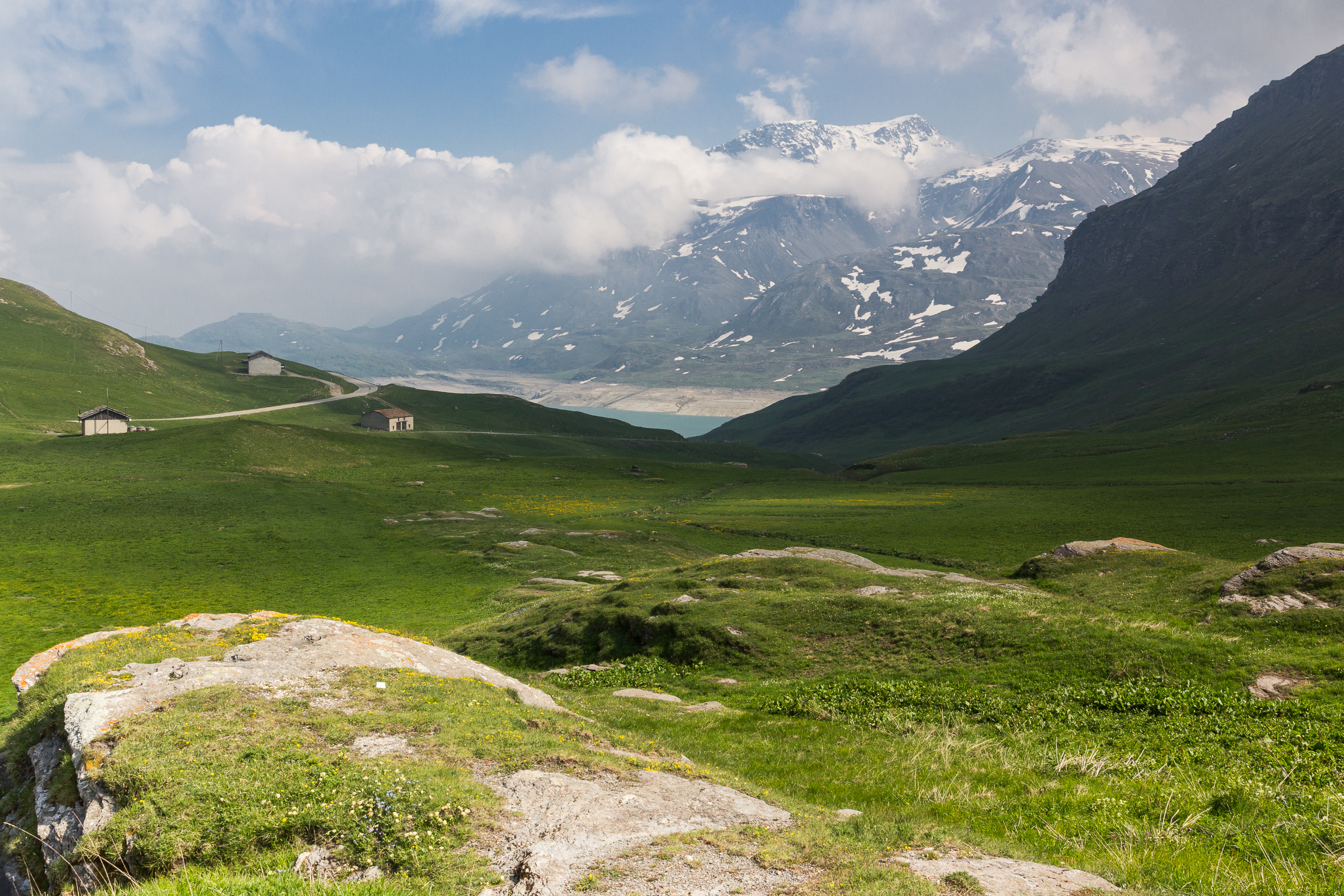 Weite Almflächen am Mont Cenis, dahinter der Stausee